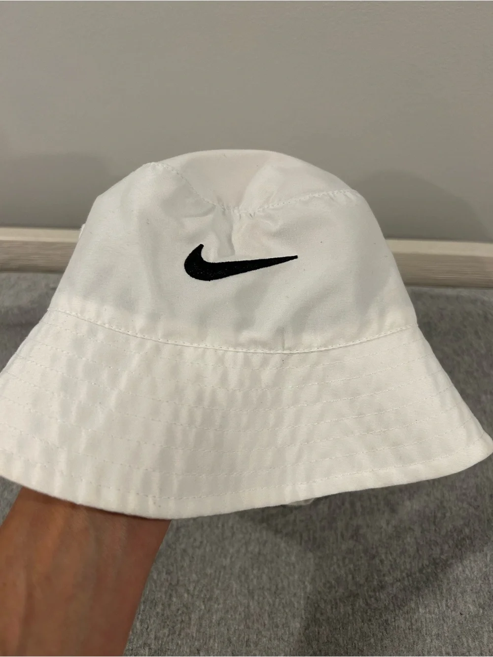 Nike Toddler White Bucket Hat with Black Swoosh Logo.